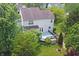 A high aerial view of the backyard featuring a deck, a patio area, and mature trees that provide shade and privacy at 6549 Wilshire Pl, Zionsville, IN 46077