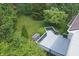 Backyard aerial view showcasing the home's deck, and a beautiful yard with mature trees and landscaping at 6549 Wilshire Pl, Zionsville, IN 46077