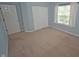 Bedroom with neutral carpet, closet, window, and light blue walls providing a serene space at 6549 Wilshire Pl, Zionsville, IN 46077