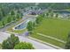 Aerial view of community with a pond and clubhouse surrounded by lush landscaping, trees, and open green spaces at 6549 Wilshire Pl, Zionsville, IN 46077