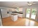 Well-lit kitchen with granite counters, white cabinets, center island, and access to the backyard at 6549 Wilshire Pl, Zionsville, IN 46077