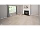 Cozy living room showcasing a fireplace, plush carpeting, and ample natural light from a large window at 6549 Wilshire Pl, Zionsville, IN 46077