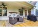 Covered back deck with outdoor seating, ceiling fans, and a grill offers a fantastic space for outdoor entertaining at 6672 Braemar S Ave, Noblesville, IN 46062
