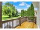 Lovely wood deck with brown railings overlooks a grassy lawn with lush landscaping and mature trees at 6672 Braemar S Ave, Noblesville, IN 46062