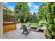 Spacious backyard with paver patio, chairs, fire pit, and lush landscaping at 6672 Braemar S Ave, Noblesville, IN 46062