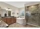 Elegant bathroom featuring a walk-in shower, a soaking tub, and a vanity with granite countertops at 6672 Braemar S Ave, Noblesville, IN 46062