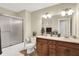 Well-lit bathroom with double sinks, a framed mirror, and tiled shower at 6672 Braemar S Ave, Noblesville, IN 46062
