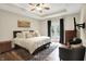 Spacious bedroom with tray ceiling, hardwood floors, and double doors to outdoor deck at 6672 Braemar S Ave, Noblesville, IN 46062