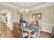 Elegant dining room with natural light, chandelier, hardwood floors, and seating for six at 6672 Braemar S Ave, Noblesville, IN 46062