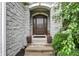 Close up of a stone entryway with a beautifully carved dark wood front door at 6672 Braemar S Ave, Noblesville, IN 46062