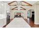 Open-concept kitchen boasts a long island, stainless steel appliances, and vaulted ceiling with wooden beams at 6672 Braemar S Ave, Noblesville, IN 46062