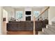 Spacious living room features a fireplace, flat screen TV, hardwood floors, and staircase at 6672 Braemar S Ave, Noblesville, IN 46062