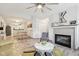 Bright living room with a fireplace, ceiling fan, open to the dining area and kitchen at 6711 Bridgefield Way, Indianapolis, IN 46254