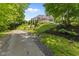 A long driveway curves to a beautiful backyard with a view of the home's expansive deck at 7016 Royal Oakland Way, Indianapolis, IN 46236