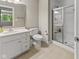 Neutral bathroom featuring a glass-enclosed shower, white vanity, toilet and a large mirror at 7016 Royal Oakland Way, Indianapolis, IN 46236