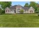 Charming stone home with red shutters, a manicured lawn, and a welcoming front porch at 7016 Royal Oakland Way, Indianapolis, IN 46236