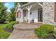 Inviting front porch with stone accents, white trim, rocking chairs, and landscaping at 7016 Royal Oakland Way, Indianapolis, IN 46236