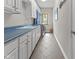 Well-lit laundry room with ample counter space, storage cabinets, and a decorative stained glass window at 7016 Royal Oakland Way, Indianapolis, IN 46236