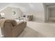 Bright living room features a beige sofa and armchair, complemented by natural light from a window at 7016 Royal Oakland Way, Indianapolis, IN 46236