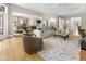 Open concept living space with hardwood floors, large area rug, and a seamless flow to the dining area at 7016 Royal Oakland Way, Indianapolis, IN 46236