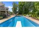 A clear blue in-ground pool with diving board, surrounded by lounge chairs, is perfect for summer relaxation at 7016 Royal Oakland Way, Indianapolis, IN 46236