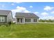 Large backyard featuring a covered porch and view of the gray exterior of the home at 7248 Covington St, Lebanon, IN 46052