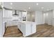 Open kitchen featuring white cabinetry, stainless steel appliances, a center island, and hardwood floors at 7248 Covington St, Lebanon, IN 46052