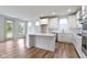Bright kitchen with a center island, white cabinetry, stainless steel appliances, and hardwood flooring at 7248 Covington St, Lebanon, IN 46052