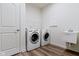 Functional laundry room features a washer, dryer, utility sink, and wood-look flooring at 7248 Covington St, Lebanon, IN 46052