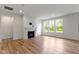 Bright living room featuring a fireplace, hardwood floors, and large windows at 7248 Covington St, Lebanon, IN 46052
