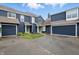 Exterior of blue townhomes with private driveways and attached garages on a sunny day at 7510 Harbour, Indianapolis, IN 46240