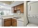 This kitchen shows a stainless steel sink, white countertops, wooden cabinets, and laundry hookups at 7510 Harbour, Indianapolis, IN 46240