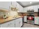 Traditional-style kitchen with stainless steel appliances, white cabinetry, and stylish backsplash at 7940 Sunfield Ct, Indianapolis, IN 46214