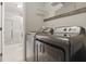 Clean laundry room featuring tiled floors, washer and dryer, and an adjacent bathroom at 7940 Sunfield Ct, Indianapolis, IN 46214