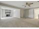 Large living room featuring neutral walls, carpet flooring, a fan, and a stone fireplace at 7940 Sunfield Ct, Indianapolis, IN 46214