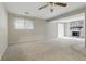 Spacious living room featuring neutral walls, carpet flooring, a fan, and a stone fireplace at 7940 Sunfield Ct, Indianapolis, IN 46214