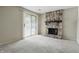 Open living room featuring neutral walls, carpet flooring, a sliding glass door, and a stone fireplace at 7940 Sunfield Ct, Indianapolis, IN 46214