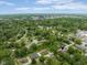 Aerial view of the property within a lush, green neighborhood, with the city skyline visible in the distance at 800 E 104Th St, Carmel, IN 46280