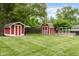 Well maintained backyard with two storage sheds, lush green lawn, and wooden privacy fence at 800 E 104Th St, Carmel, IN 46280