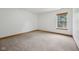 Empty bedroom with neutral walls, plush carpet, and a window offering natural light at 8241 Holmard Pl, Indianapolis, IN 46259