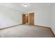 Spacious bedroom featuring neutral carpet, and wood trim with multiple doors at 8241 Holmard Pl, Indianapolis, IN 46259
