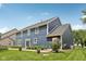 Back exterior features a stone patio, beautifully landscaped yard and a lush green lawn, creating a serene outdoor setting at 8241 Holmard Pl, Indianapolis, IN 46259