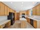 Kitchen with light wood cabinetry, an island, and black appliances offers ample counter space at 8241 Holmard Pl, Indianapolis, IN 46259