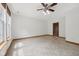 Bright living room featuring neutral walls, light flooring, and a ceiling fan with light fixture at 8241 Holmard Pl, Indianapolis, IN 46259