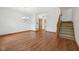 Living room featuring hardwood floors, with stairs and a door leading to the kitchen at 8241 Holmard Pl, Indianapolis, IN 46259