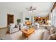 Staged living room with tile floors and neutral colors flows seamlessly into the kitchen and dining area at 8241 Holmard Pl, Indianapolis, IN 46259