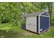 Close-up of a well-maintained storage shed on a lush green lawn, offering ample storage space at 8241 Holmard Pl, Indianapolis, IN 46259