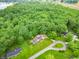Panoramic aerial shot displays a home with ample greenery and a location near a serene lake amidst a lush, wooded landscape at 8772 W Evergreen Dr, Columbus, IN 47201