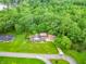 This aerial photo shows a home with a vast, green lawn and a surrounding canopy of trees, offering a private, serene setting at 8772 W Evergreen Dr, Columbus, IN 47201