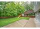 A view of the backyard with a playset, a lawn and lots of mature trees at 8772 W Evergreen Dr, Columbus, IN 47201